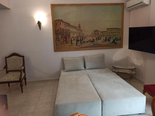 1 dormitorio con 1 cama y una pintura en la pared en OLD ZAKYNTHOS GALLERY GIO 2 en Zakynthos