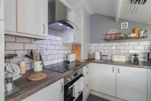 a kitchen with white cabinets and a counter top at Luxury Cottage Nestled in the Heart of Pickering - Pet Friendly in Pickering