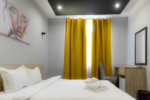 a bedroom with a bed and a yellow curtain at Verdisso Hotel & Restaurant in Demir Kapija