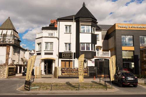 ein großes weißes Gebäude mit einem Schild davor in der Unterkunft Lezzet Hotel & Turkish Restaurant in Warschau