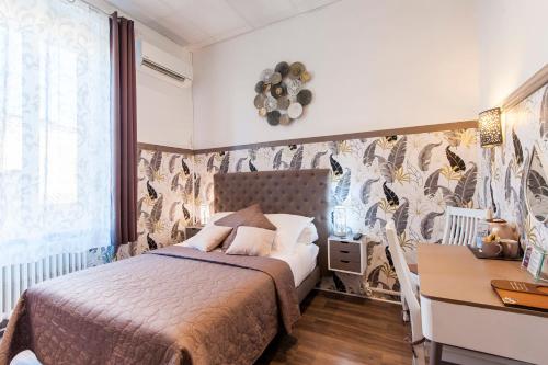 a bedroom with a bed and a desk at Hôtel de Charme Le Provence in Salon-de-Provence