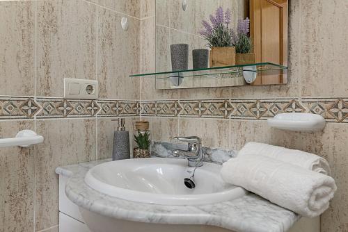 uma casa de banho com um lavatório e um espelho em urbanización Catamaran em Denia