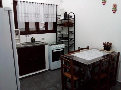 uma cozinha com uma mesa, um lavatório e um fogão em Excellence Apart em Ubatuba