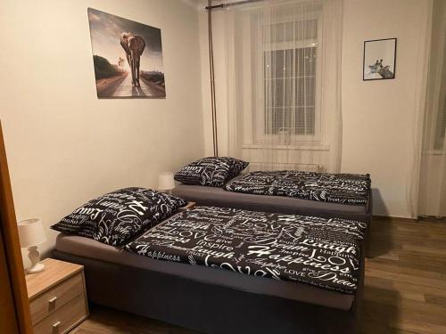 a bedroom with two beds and a picture on the wall at Černý Tulipán - Apartmán 2 in Pilsen