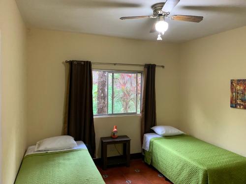 2 camas en una habitación con ventana en Casa Verónica a 2 kilometros del IRTRA, en Retalhuleu