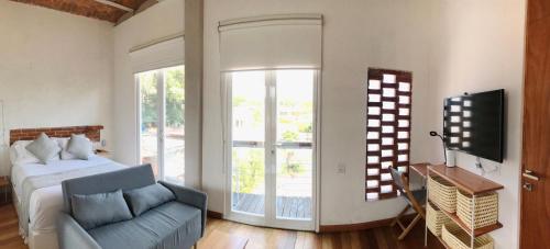 a bedroom with a bed and a couch and a tv at Sisao Hotel-Café in Cuernavaca