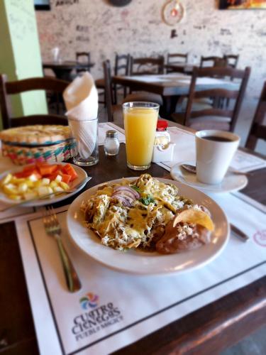 a table with a plate of food and orange juice at Hotel Plaza Cuatro Ciénegas in Cuatrociénegas de Carranza