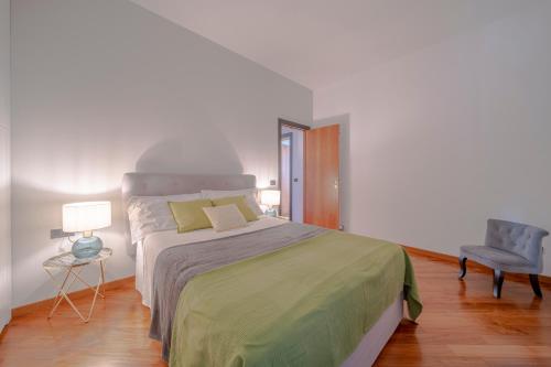 a bedroom with a large bed and a chair at Villa Liana in Vinci