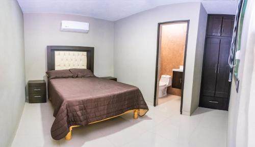 a small bedroom with a bed and a bathroom at Hotel EL MILAGRO in El Fuerte