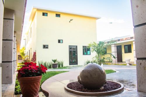 a building with a fountain in a courtyard with flowers at Hotel EL MILAGRO in El Fuerte