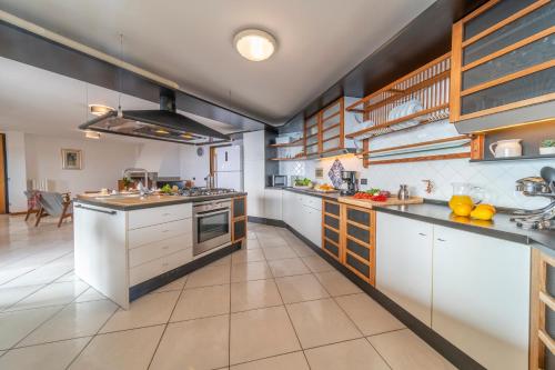 a large kitchen with white cabinets and counters at Villa Liana in Vinci