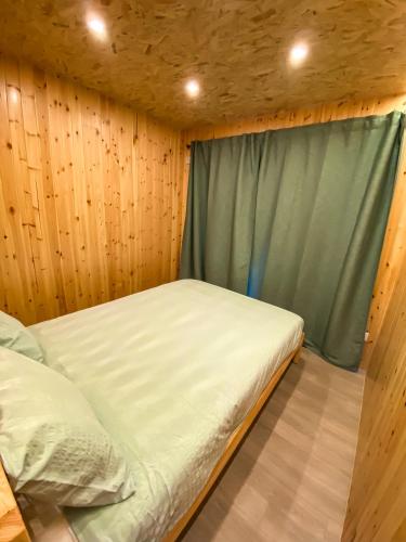 a small bedroom with a bed and a window at Pichoses Gerês Camping in Rio Caldo