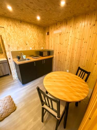 a kitchen with a wooden table and chairs in a room at Bungalow Gerês - Pichoses Camping in Rio Caldo