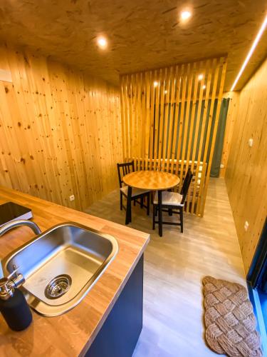 a kitchen with a sink and a table in a room at Bungalow Gerês - Pichoses Camping in Rio Caldo