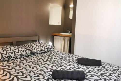 a bedroom with a bed with black and white sheets at Splendide Maison 5 chambres ! Quartier Historique in Limoges