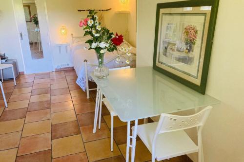 a dining room with a table with a vase of flowers at La Belle Vue - Coin de paradis in Sussac