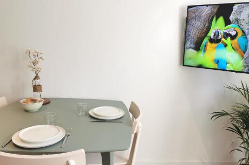 una mesa de comedor con sillas y una pintura en la pared en Lovely T2 - Proche du CHU LIMOGES, en Isle