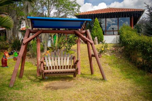a swing set with a chair in a yard at Hacienda Buenos Aires en Iza in Iza