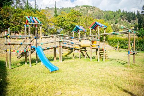 a park with a playground with slides and a slide at Hacienda Buenos Aires en Iza in Iza