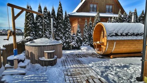 a wooden igloo in the snow in front of a house at Drevenička Anička - Liptovská Mara in Liptovský Trnovec
