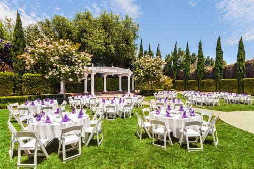 a wedding reception in the garden with white tables and chairs at Handlery Hotel San Diego in San Diego