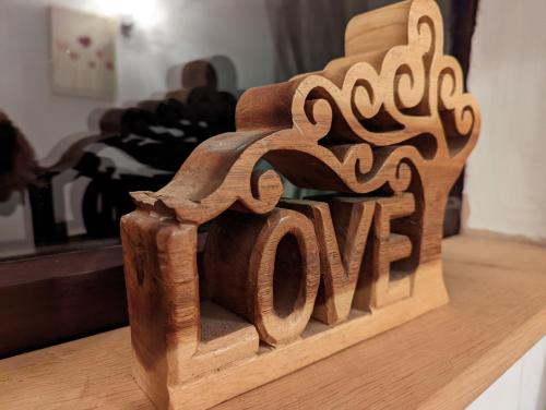 a wooden sign that says love sitting on a table at Beautiful rural cottage with secure garden in Bradley