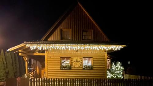 a wooden house with christmas lights on it at Drevenička Anička - Liptovská Mara in Liptovský Trnovec