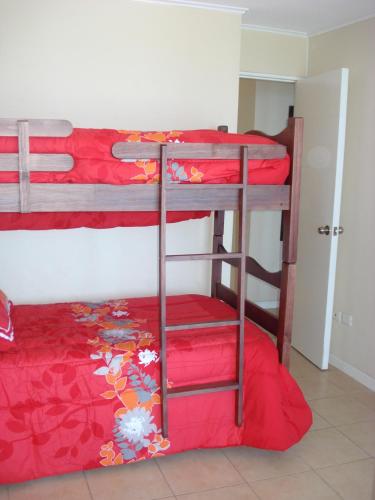 two bunk beds in a room with red sheets at La Serena Sol y Mar in La Serena