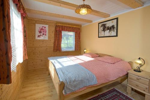 ein Schlafzimmer mit einem Bett in einem Blockhaus in der Unterkunft Das Altsteirische Landhaus - La Maison de Pronegg - Feriendomizil im Biosphärenpark Wienerwald in Pressbaum