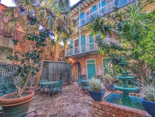 a courtyard with a fountain in front of a building at Bon Maison Guest House in New Orleans