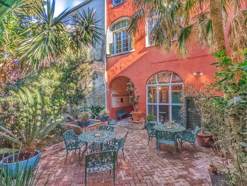 ニューオーリンズにあるBon Maison Guest Houseの建物の前のテーブルと椅子のあるパティオ