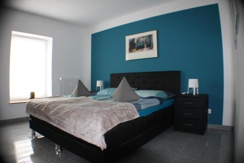 a blue bedroom with a bed and a blue wall at Apartment 60 m² in Elsdorf-Heppendorf in Elsdorf