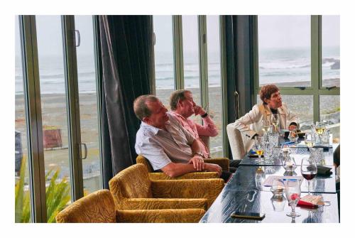 a group of people sitting at a table in a restaurant at Scenic Hotel Punakaiki in Punakaiki
