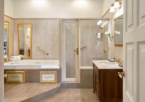 a bathroom with a tub and a sink and a shower at Terra Nova All Suite Hotel in Kingston