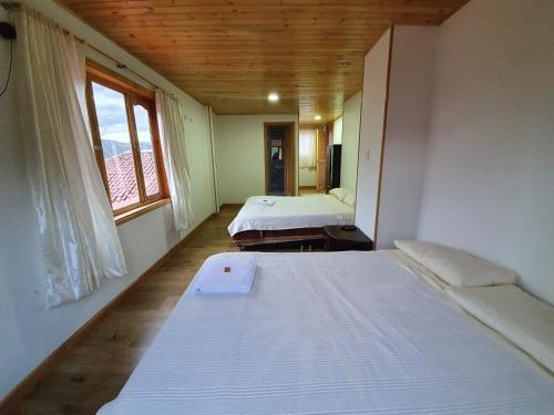 a room with two beds and a window in it at Hacienda Buenos Aires en Iza in Iza