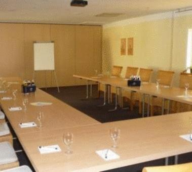 a conference room with tables and chairs with wine glasses at Landhaus Begatal in Dörentrup