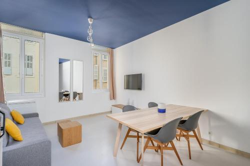 une salle à manger avec une table et des chaises en bois dans l'établissement Place de Rome, à Marseille