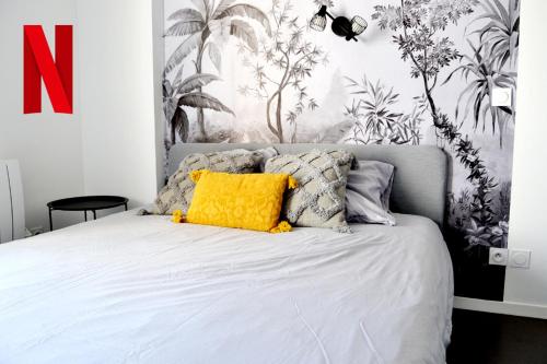 a bedroom with a bed with a yellow pillow at Studio Cosy Bordeaux - Parking privé - Netflix - Tram A in Cenon