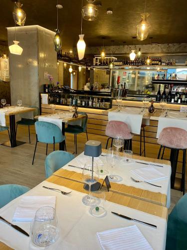 a restaurant with tables and chairs and a bar at Hotel Ivana in Lido di Jesolo