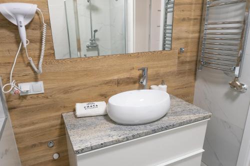 a bathroom with a white bowl sink on a counter at Chata Stylchyn in Kluszkowce