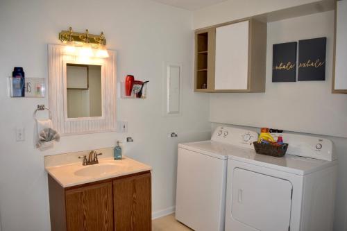 a bathroom with a washing machine and a sink at Cozy 2nd story Flat near downtown in Adrian