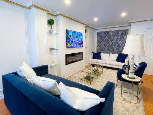 a living room with a blue couch and a tv at Luxurious Room near LaGuardia & JFK in Corona