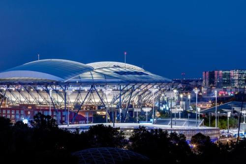 a large soccer stadium at night with a city at Luxurious Room near LaGuardia & JFK in Corona