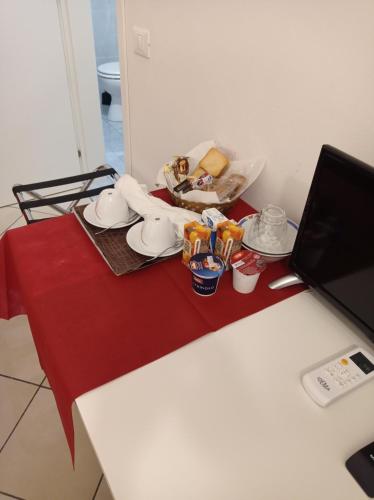 ein Tisch mit einer roten Tischdecke auf einem Tisch mit einem Laptop in der Unterkunft B&B Toscana in Pisa