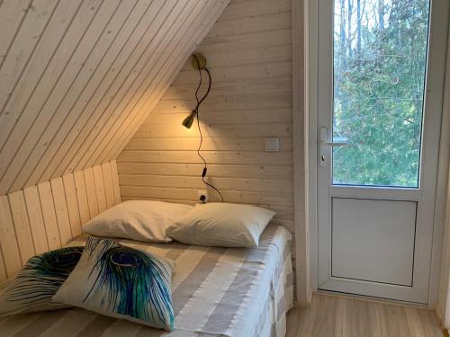1 dormitorio con 1 cama en una habitación con ventana en Mokko Saunahouse, en Änkküla