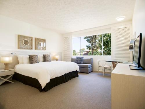 a hotel room with a bed and a television at Oaks Sunshine Coast Oasis Resort in Caloundra