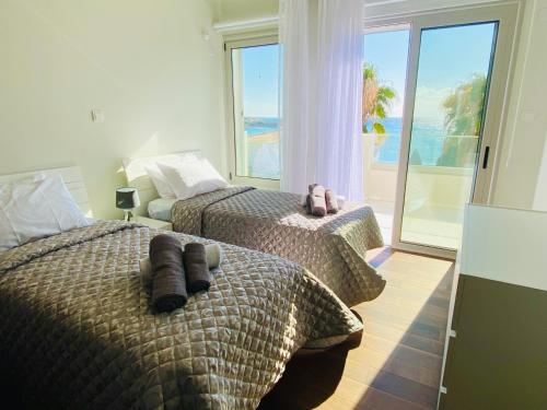 2 Betten in einem Schlafzimmer mit Meerblick in der Unterkunft coral bay beach villa in Paphos City