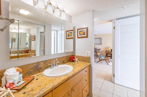 a bathroom with a sink and a mirror at Valley Isle 1108B condo in Kahana