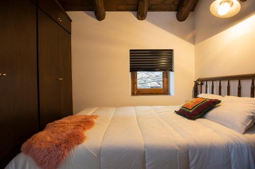 Schlafzimmer mit einem großen weißen Bett und einem Fenster in der Unterkunft JAT MOUNTAIN HOUSES - Casa Jarca 2on pis Àtic, a 1km de Canillo in Prats
