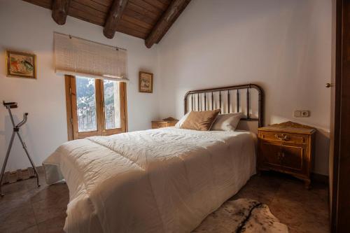 ein Schlafzimmer mit einem großen Bett und einem Fenster in der Unterkunft JAT MOUNTAIN HOUSES - Casa Jarca 2on pis Àtic, a 1km de Canillo in Prats